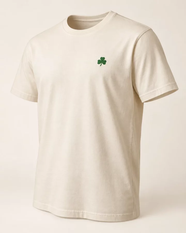 Cream Shamrock Signature T-Shirt design mock-up: Small green shamrock left chest; plain back; crew neck