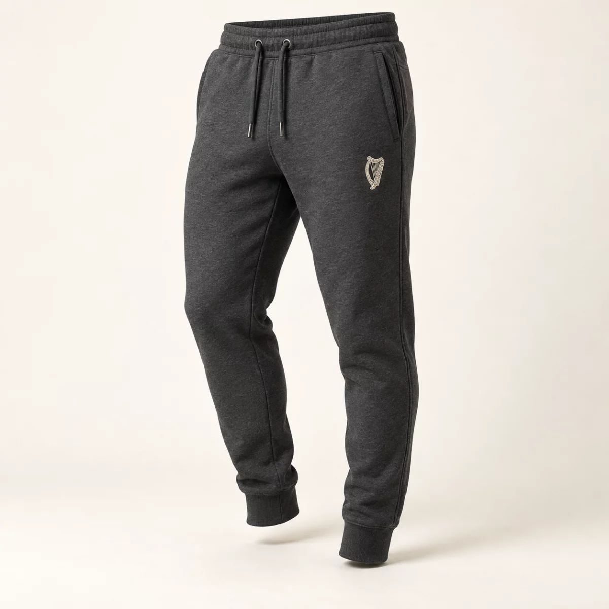 Heritage Tapered Joggers Charcoal Heritage Tapered Joggers design mock-up: Small cream harp left thigh; tapered legs; cuffed hems