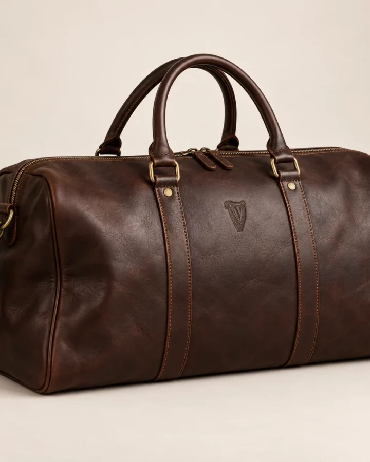 Dark brown Heritage Signature Weekender design mock-up: Dark-brown leather-look weekender; small embossed-look harp; muted brass hardware