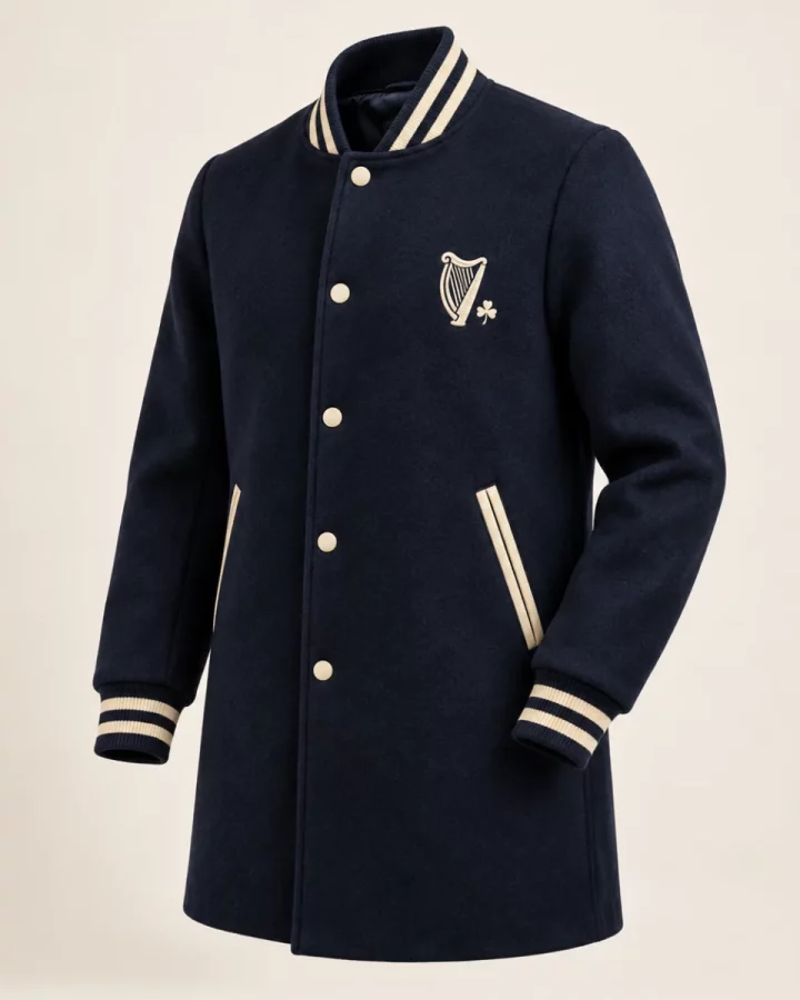 Navy District Varsity Coat design mock-up: Navy mid-thigh varsity-style coat; cream trim; small cream harp chest emblem